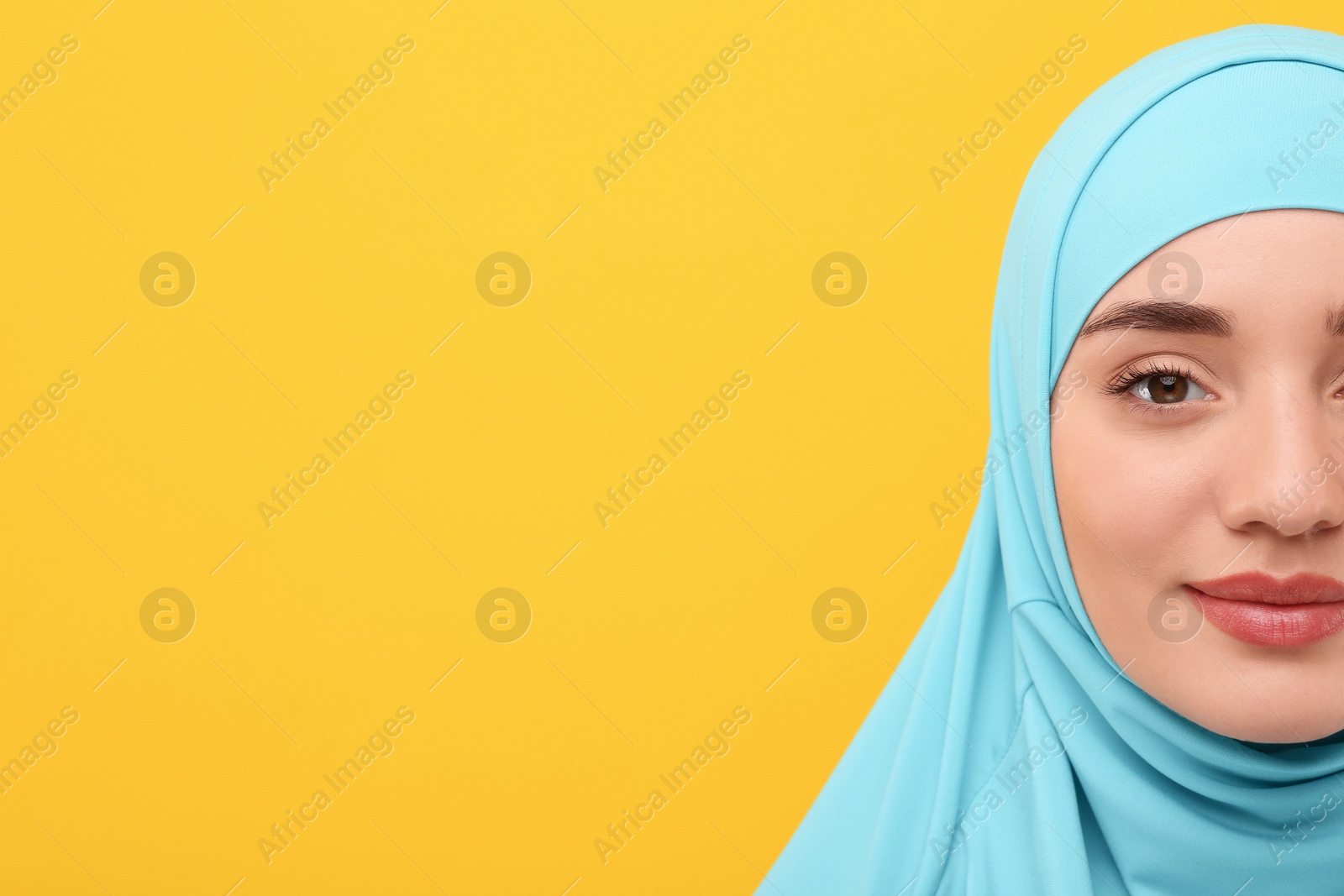 Photo of Muslim woman in hijab on orange background, closeup. Space for text