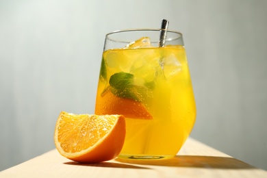 Delicious orange soda water and fresh fruit on wooden table