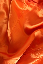 Photo of Texture of orange fabric as background, closeup