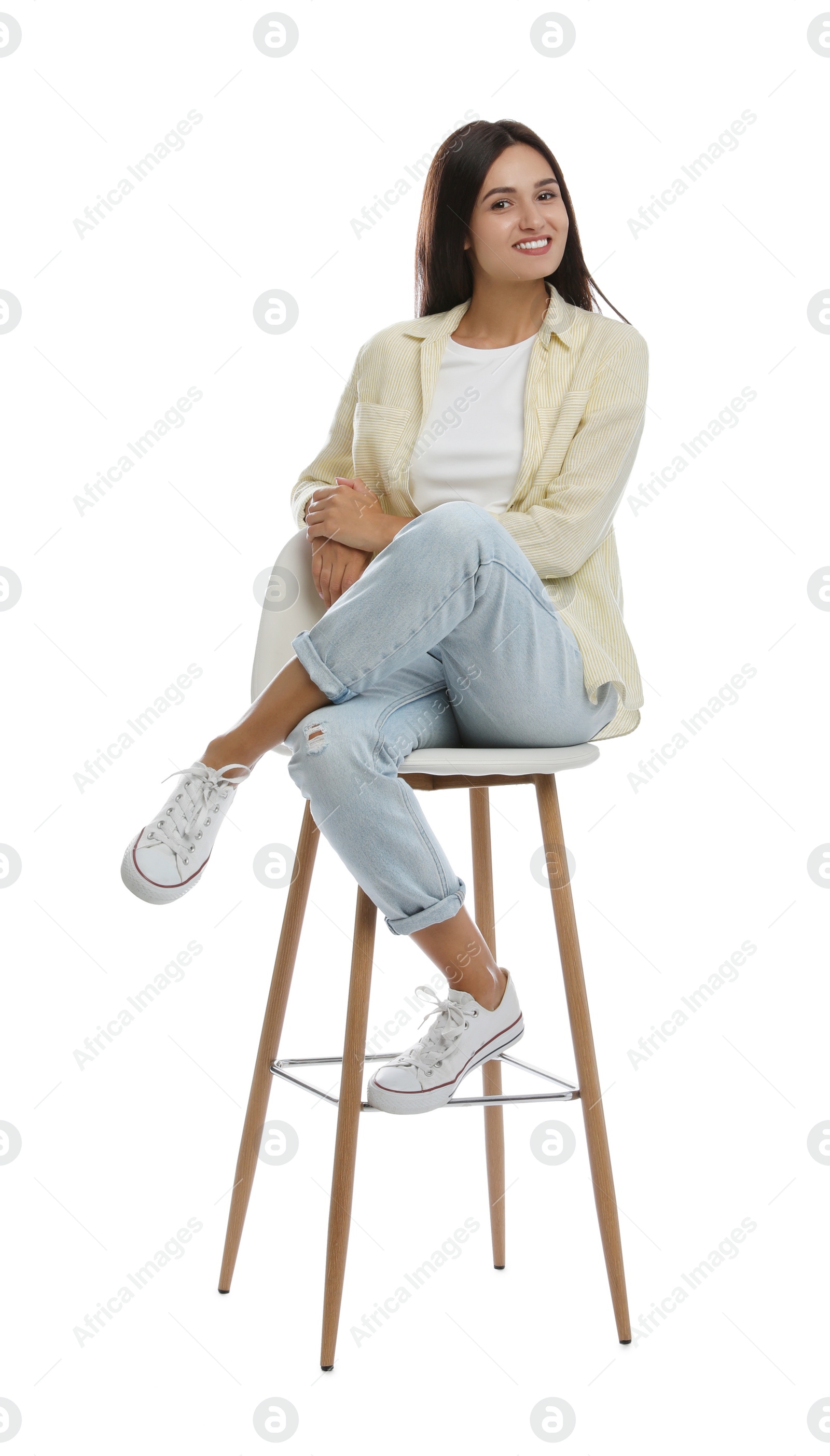 Photo of Beautiful young woman sitting on stool against white background