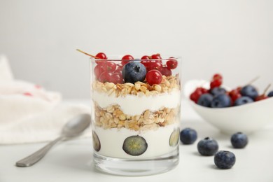 Photo of Delicious yogurt parfait with fresh berries on white table, closeup