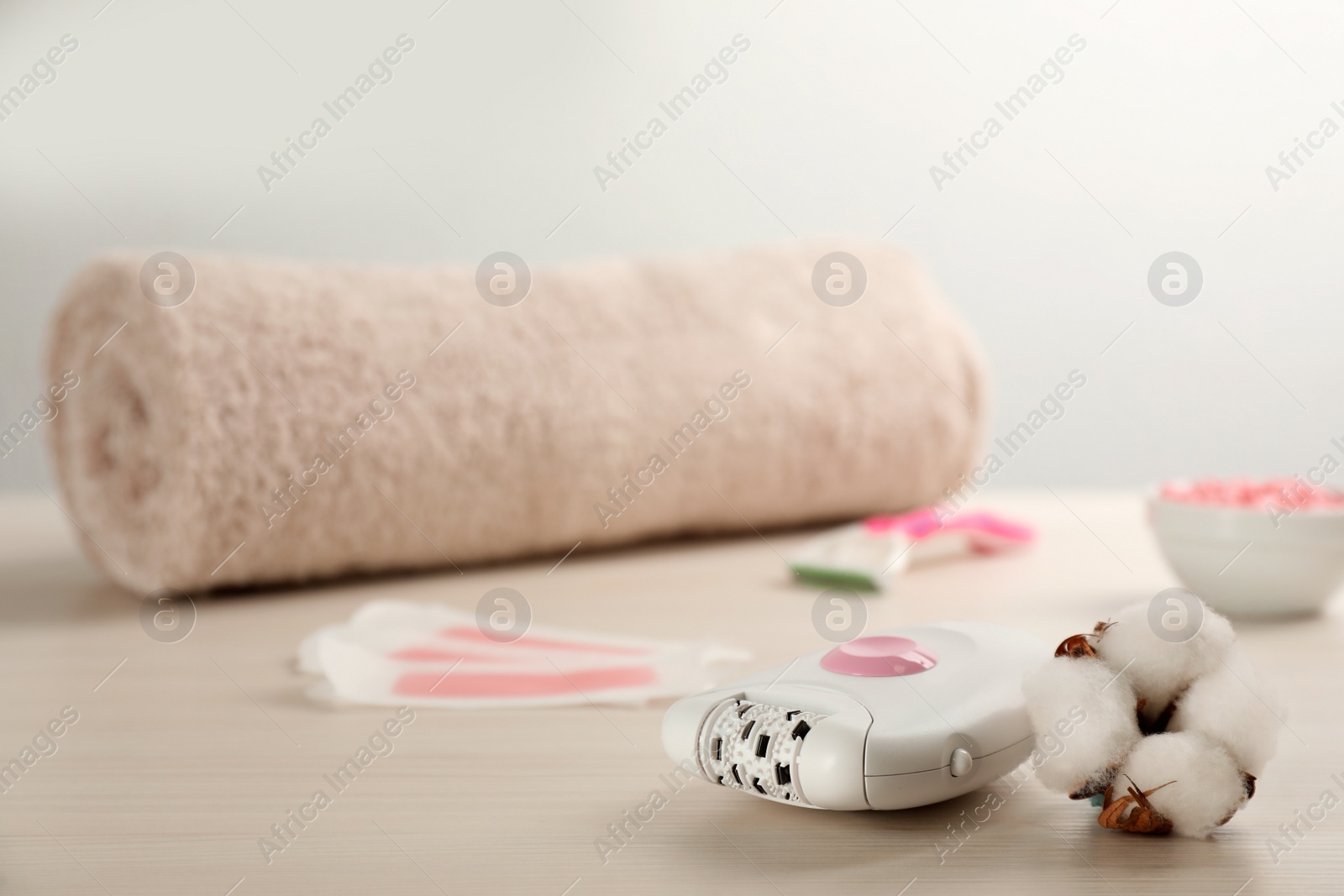 Photo of Set of epilation products and cotton flower on white wooden table. Space for text