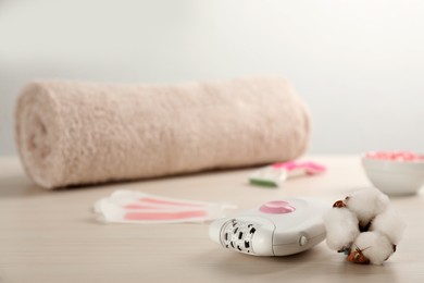 Set of epilation products and cotton flower on white wooden table. Space for text