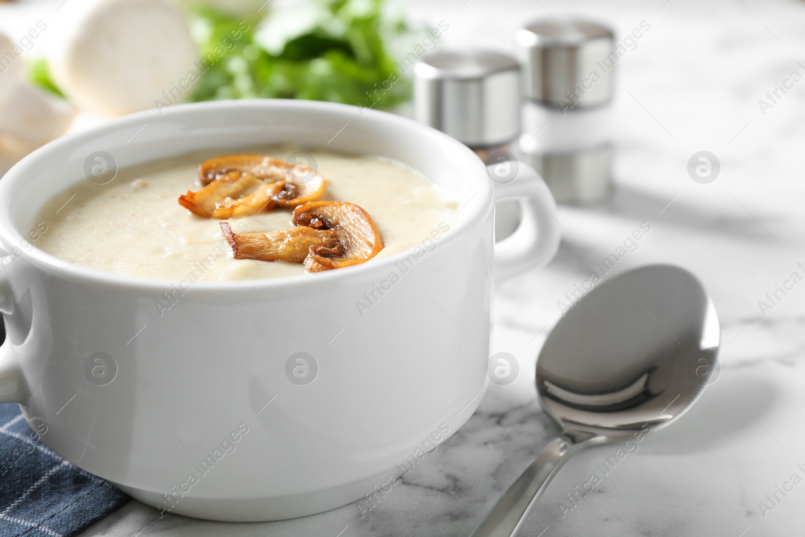 Photo of Delicious cream soup with mushrooms on white marble table, closeup