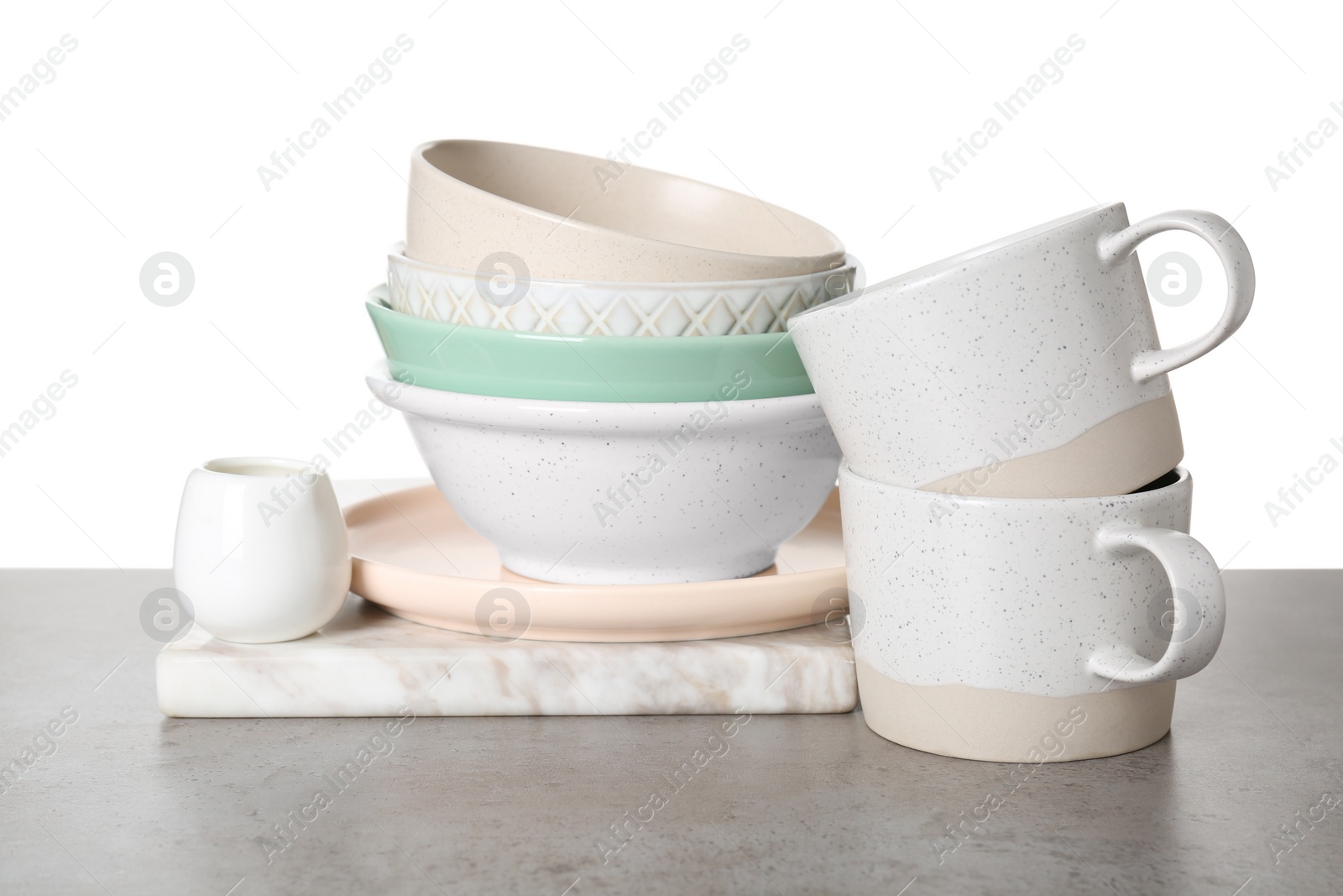 Photo of Different dishware and marble board on grey table