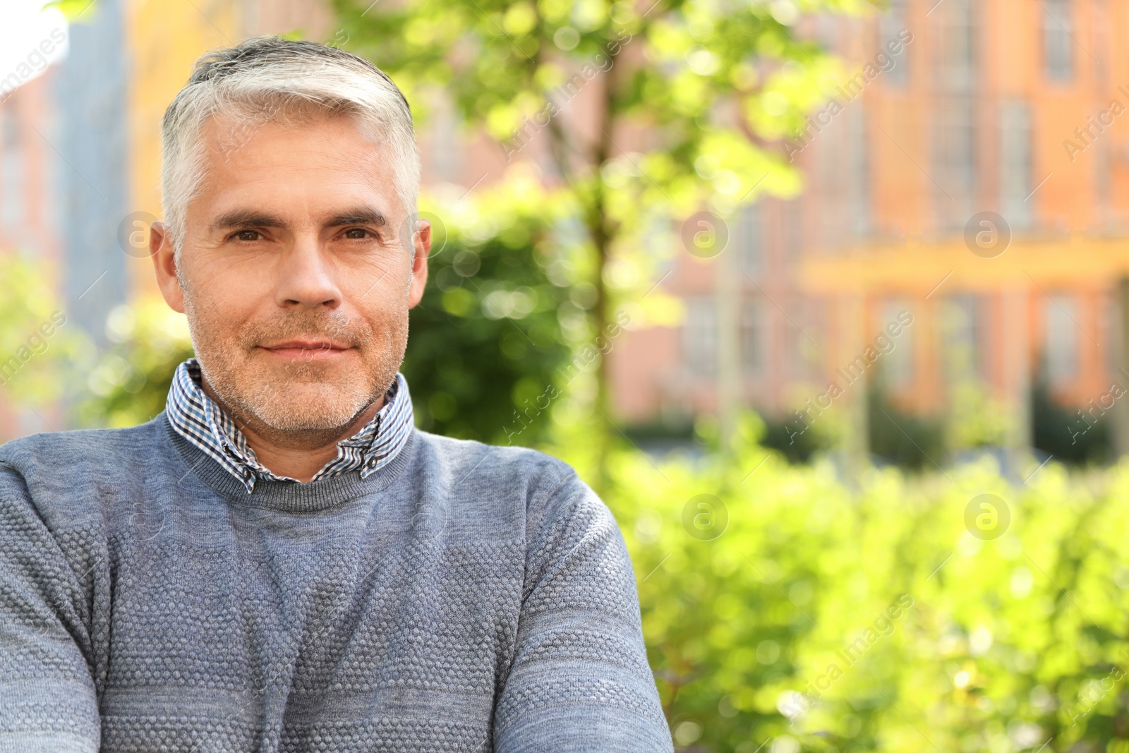 Photo of Portrait of handsome mature man in park. Space for text