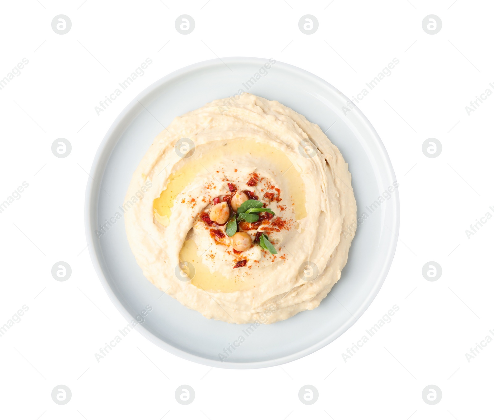 Photo of Plate of tasty hummus with garnish isolated on white, top view