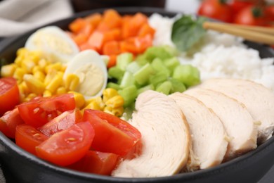 Delicious poke bowl with meat, egg, rice and vegetables, closeup