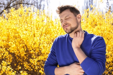 Photo of Man suffering from seasonal allergy outdoors, space for text