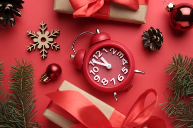 Photo of Flat lay composition with alarm clock and gifts on red background. Boxing day