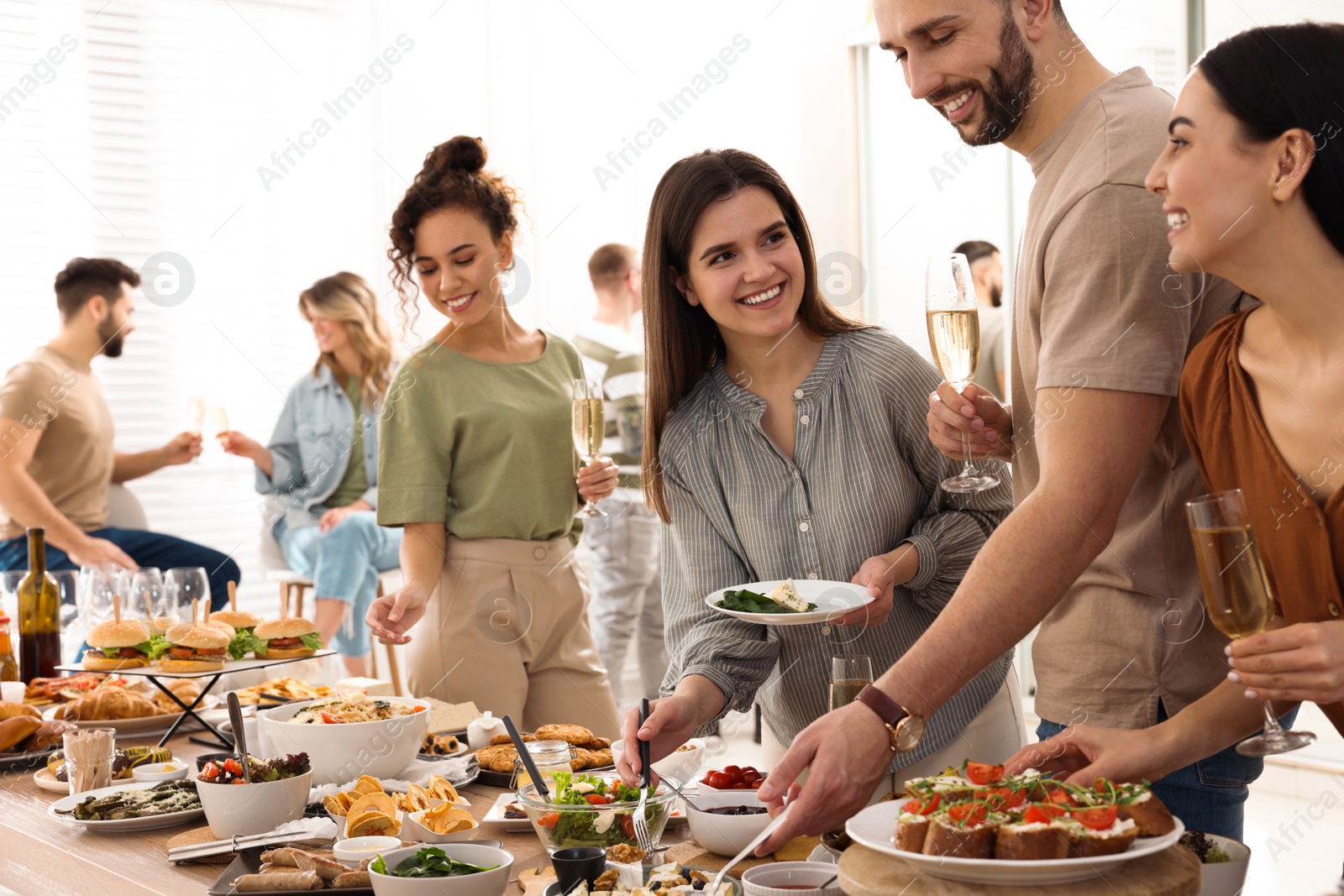 Photo of Group of people enjoying brunch buffet together indoors