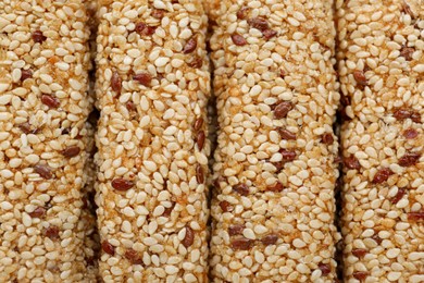 Tasty sesame seed bars as background, top view