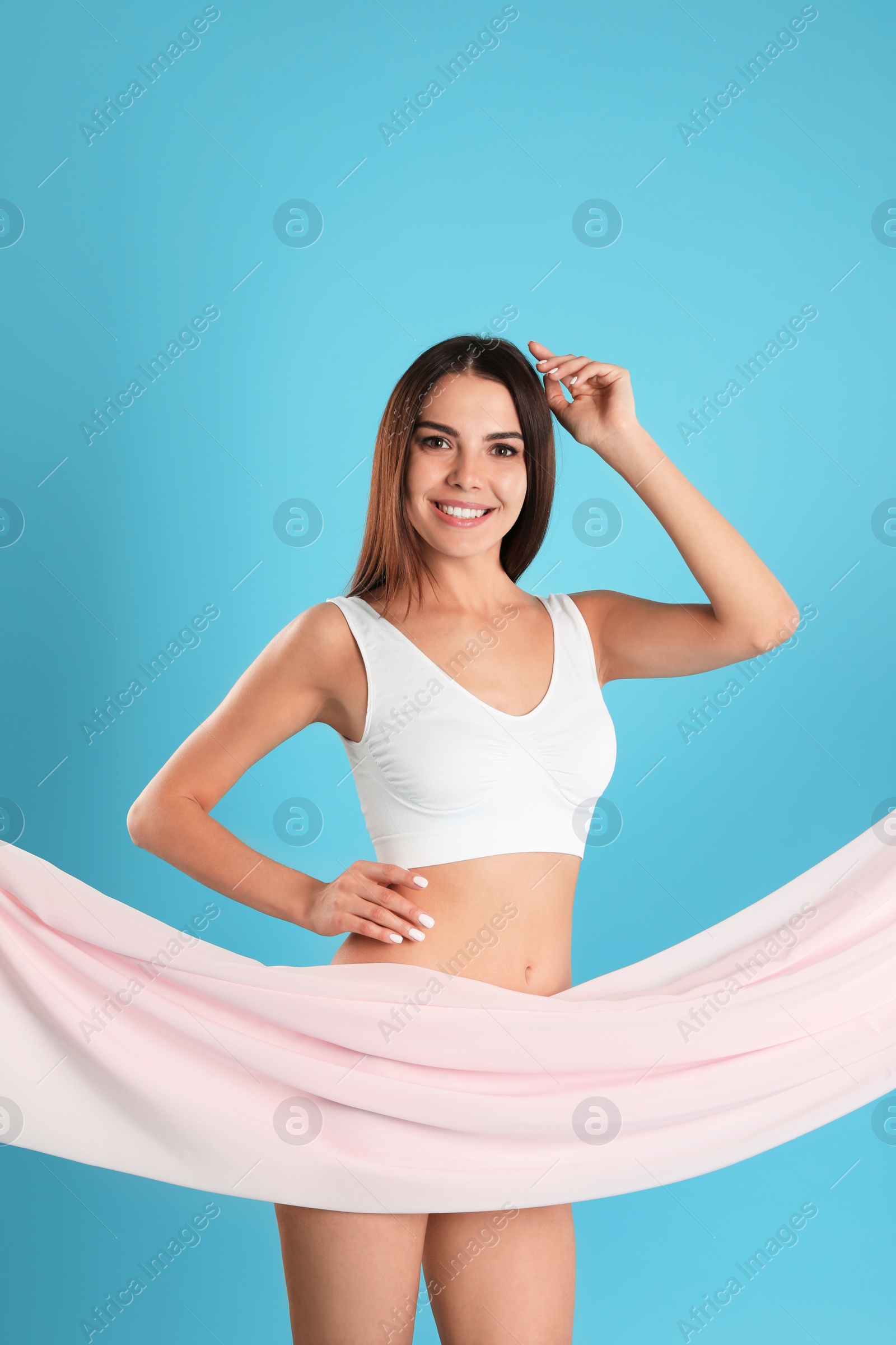 Photo of Portrait of slim young woman covering her body with fabric on color background