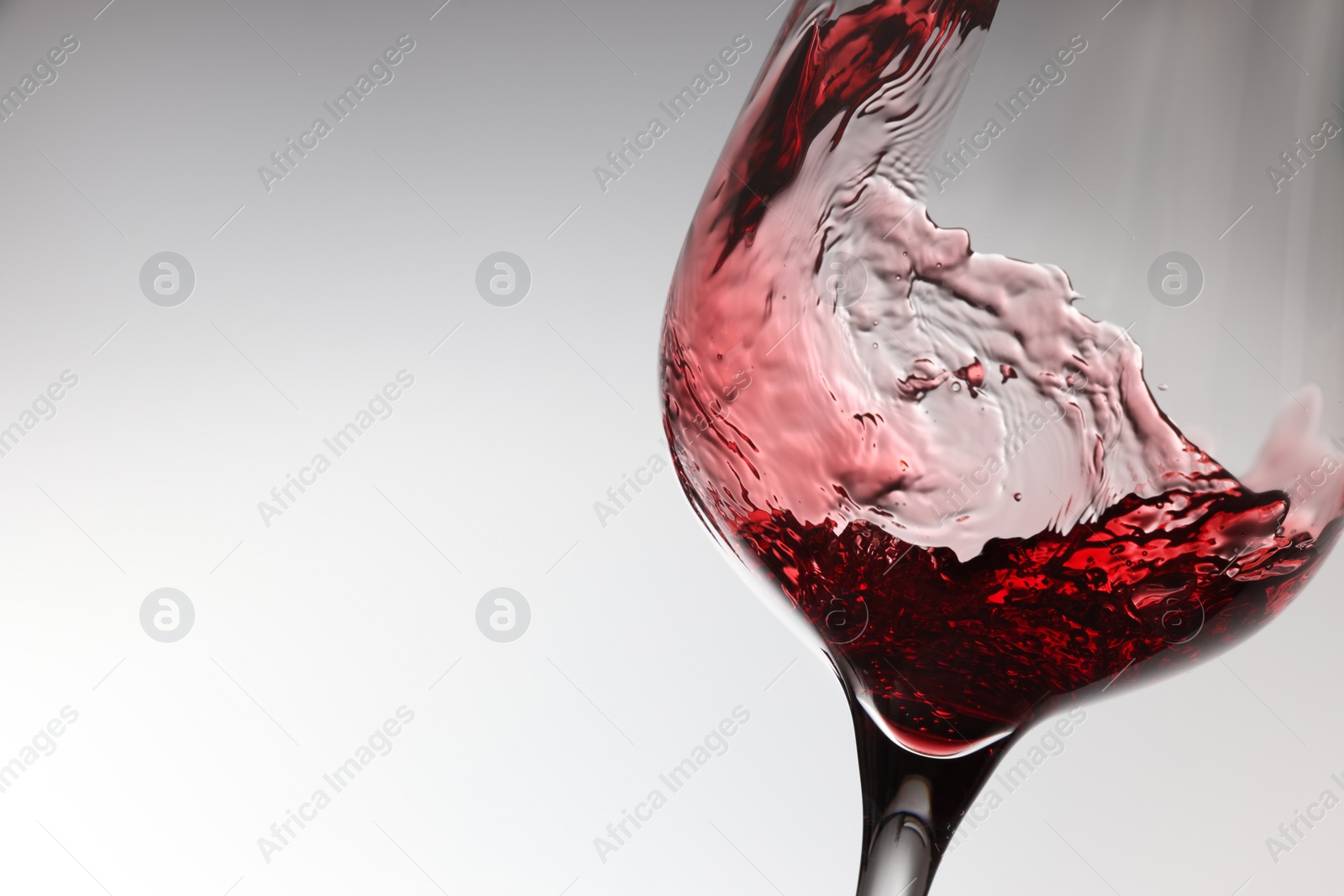 Photo of Tasty red wine in glass on white background, closeup. Space for text