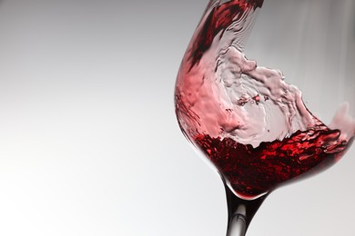 Tasty red wine in glass on white background, closeup. Space for text