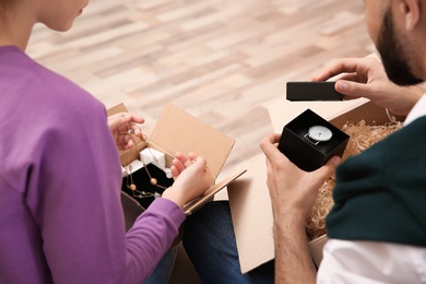 Young couple opening parcels at home, closeup