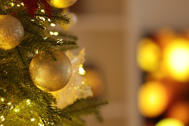 Beautiful decorated Christmas tree with baubles and festive lights on blurred background, closeup. Space for text