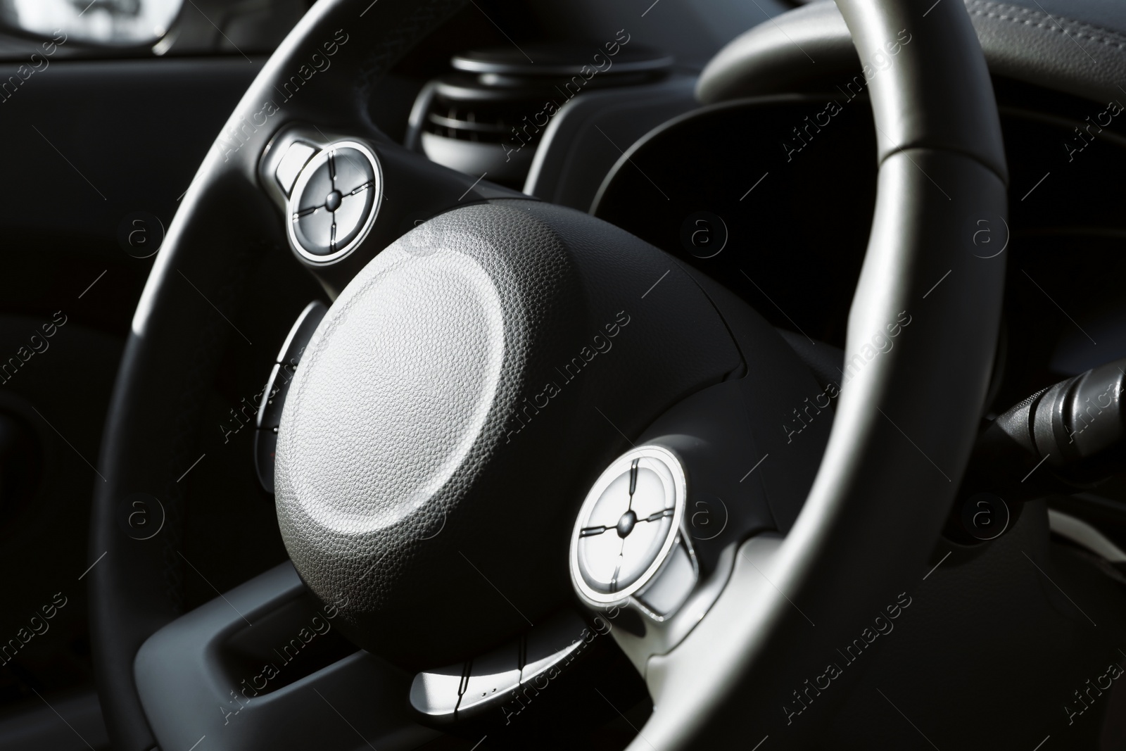 Photo of Black steering wheel inside of modern car, closeup