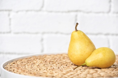 Ripe pears on table near brick wall. Space for text