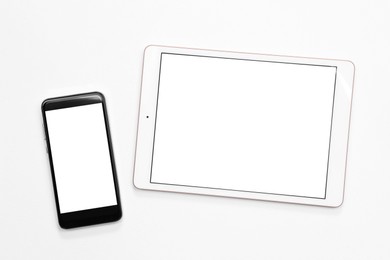 Modern tablet and smartphone on white background, flat lay. Space for text