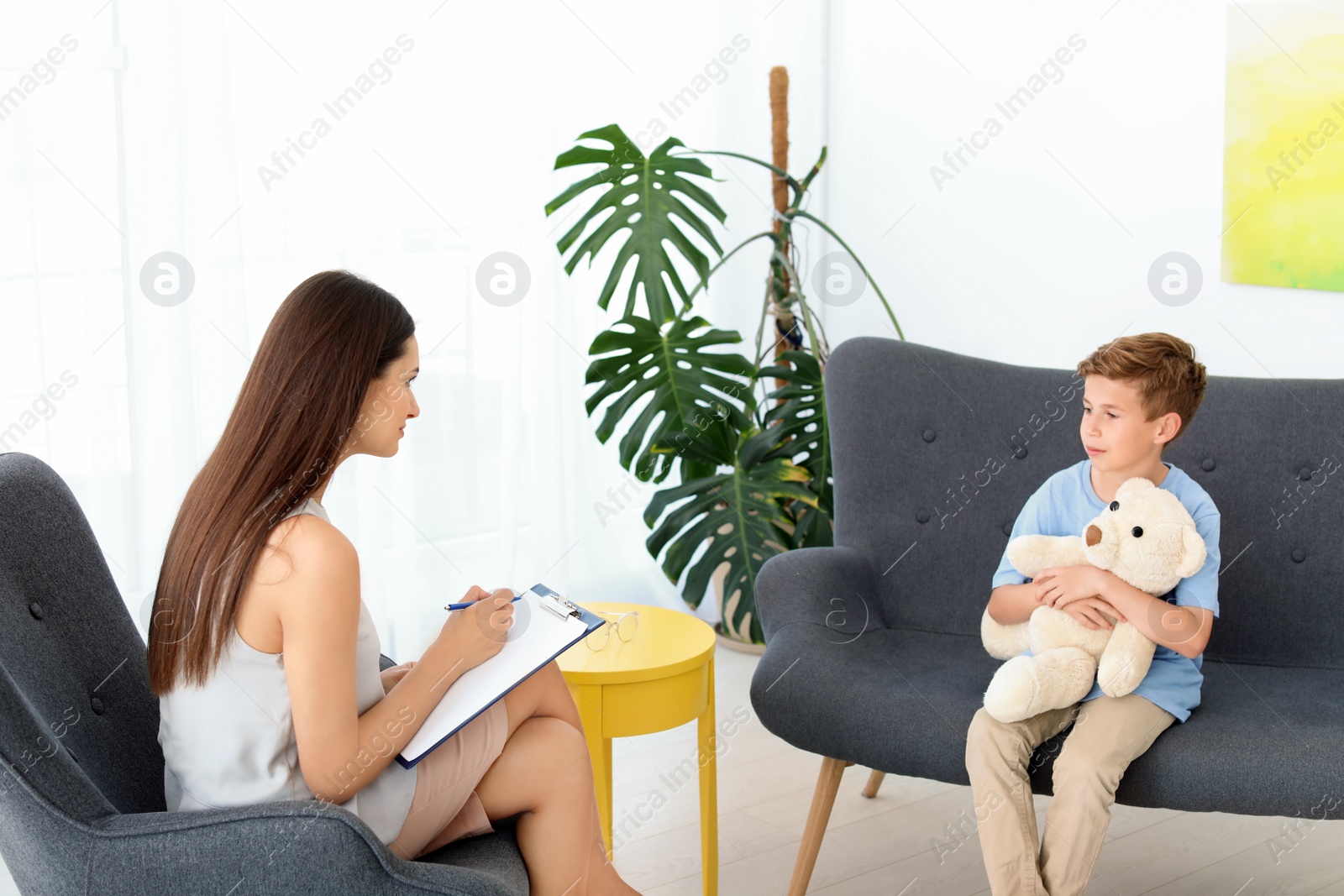 Photo of Child psychologist working with boy in office