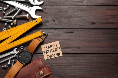 Photo of Card with phrase HAPPY FATHER'S DAY, different tools and male accessories on wooden background, flat lay. Space for text