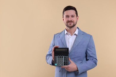 Photo of Happy accountant with calculator on beige background. Space for text