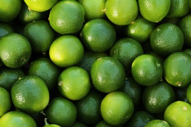 Fresh ripe green limes as background, top view