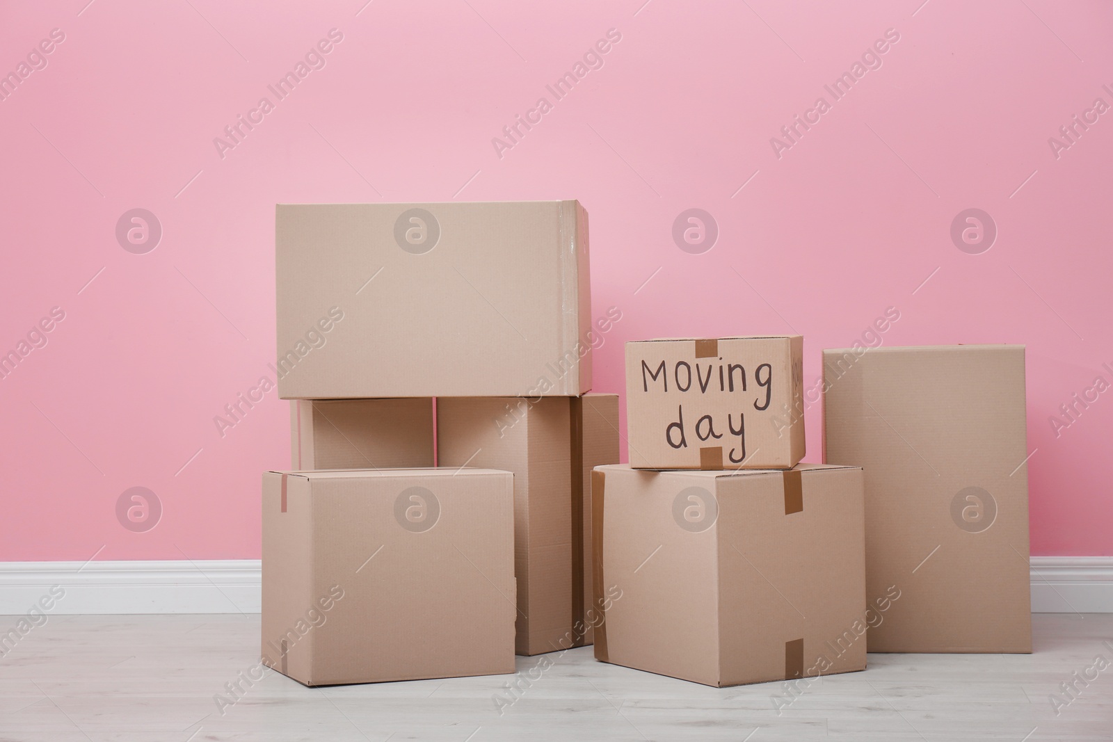 Photo of Cardboard boxes near color wall. Moving day