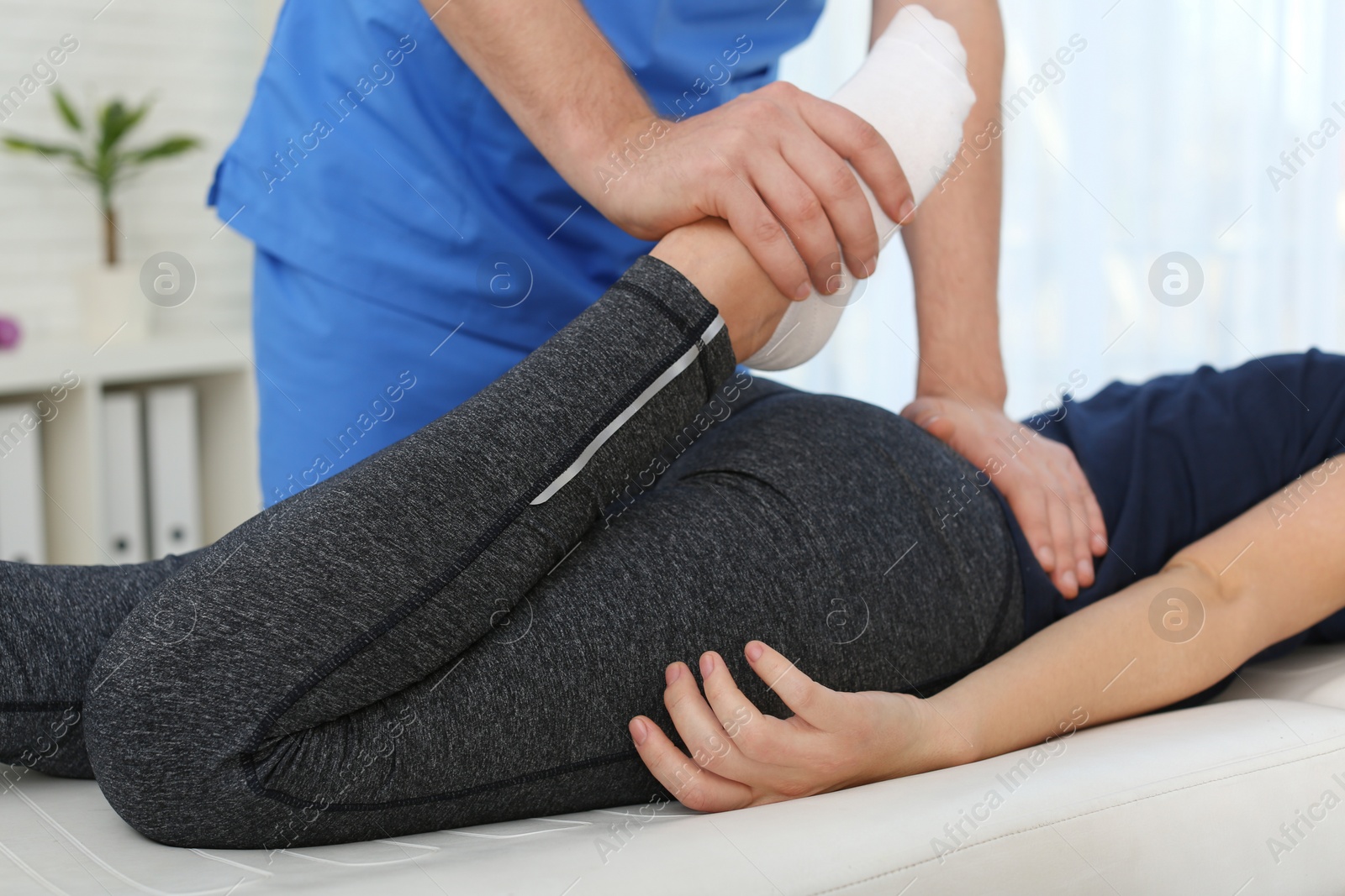 Photo of Physiotherapist working with patient in clinic, closeup. Rehabilitation therapy