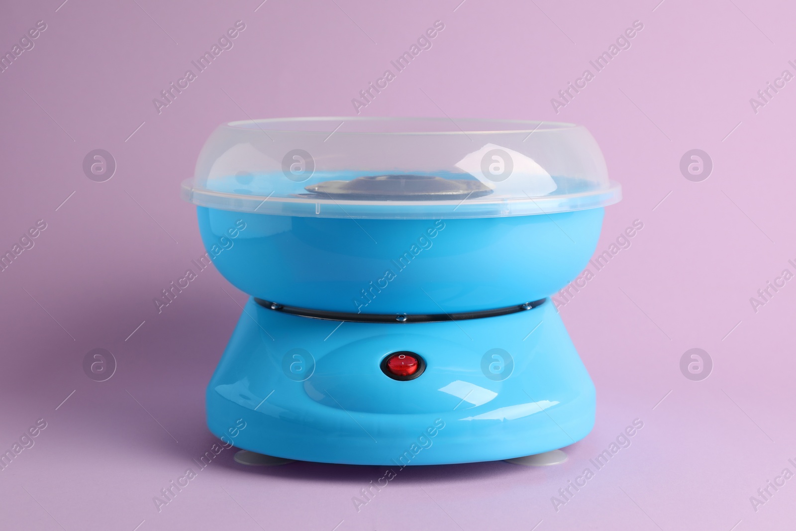 Photo of Portable candy cotton machine on violet background