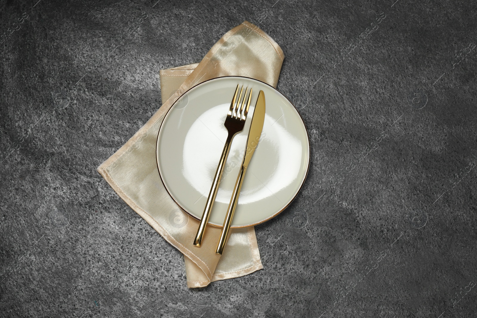 Photo of Stylish setting with elegant cutlery on grey table, top view