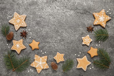 Photo of Tasty Christmas cookies, fir branches, cones and anise on grey table, flat lay. Space for text