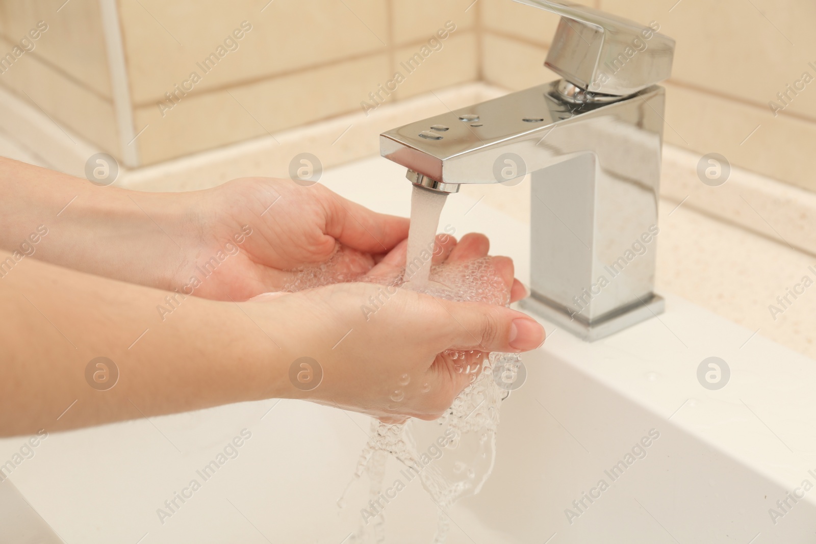 Photo of Woman washing hands with antiseptic soap in bathroom, closeup