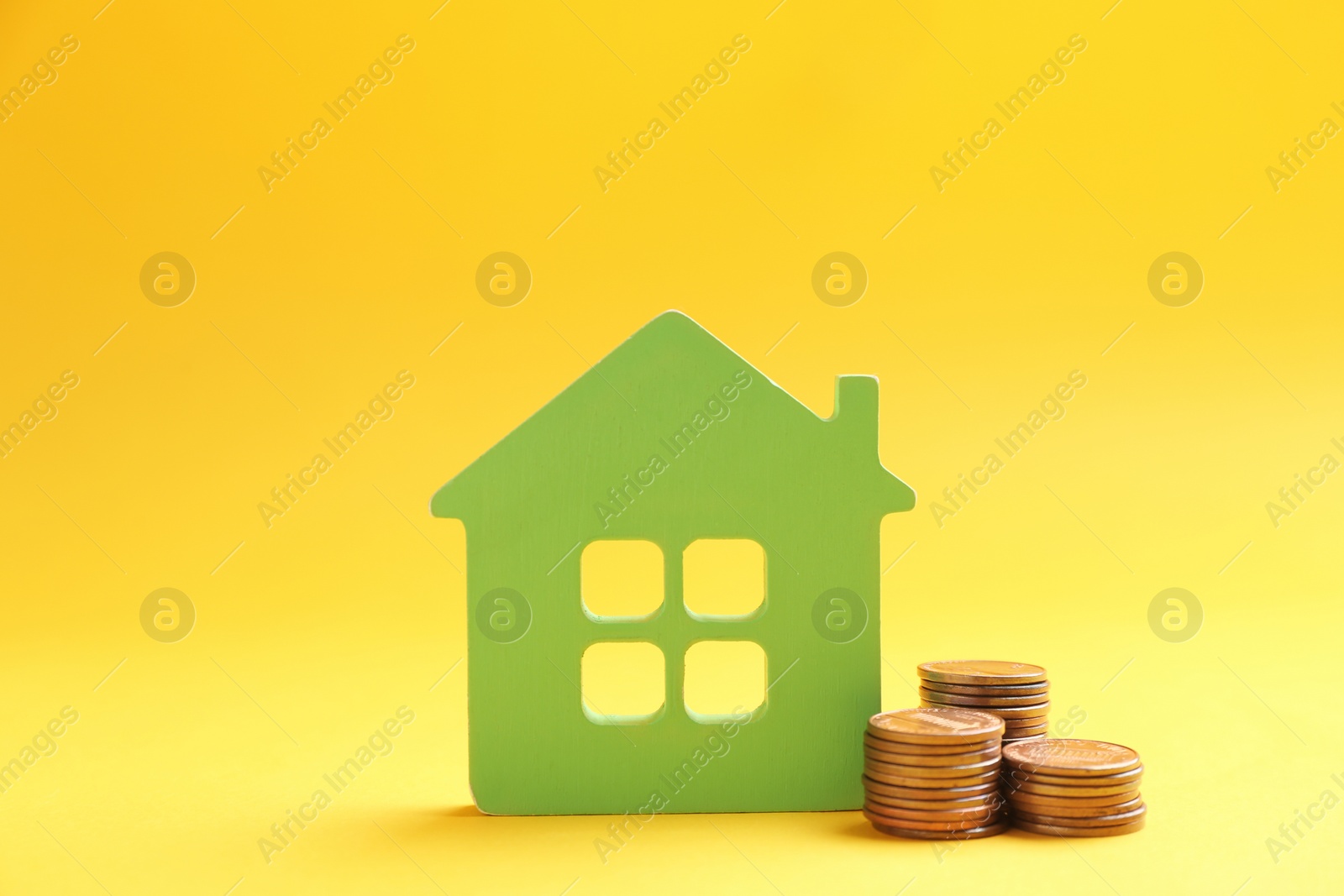 Photo of House figure and coins on color background