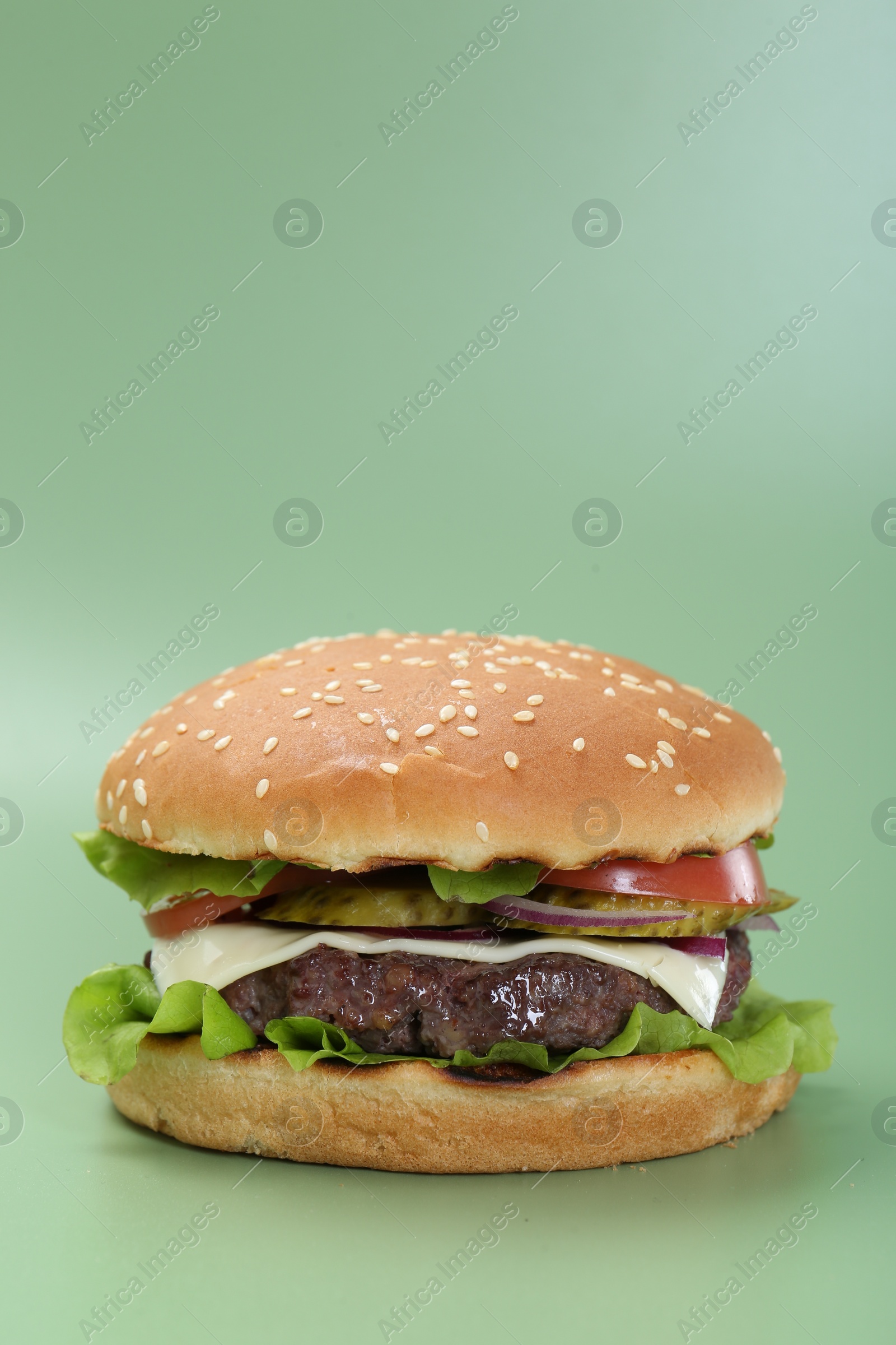 Photo of Burger with delicious patty on green background