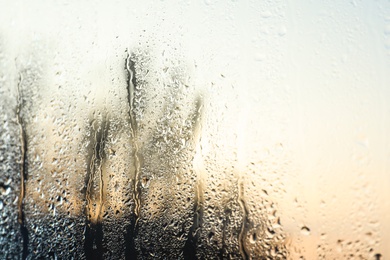 Photo of Rain drops on window glass as background, closeup