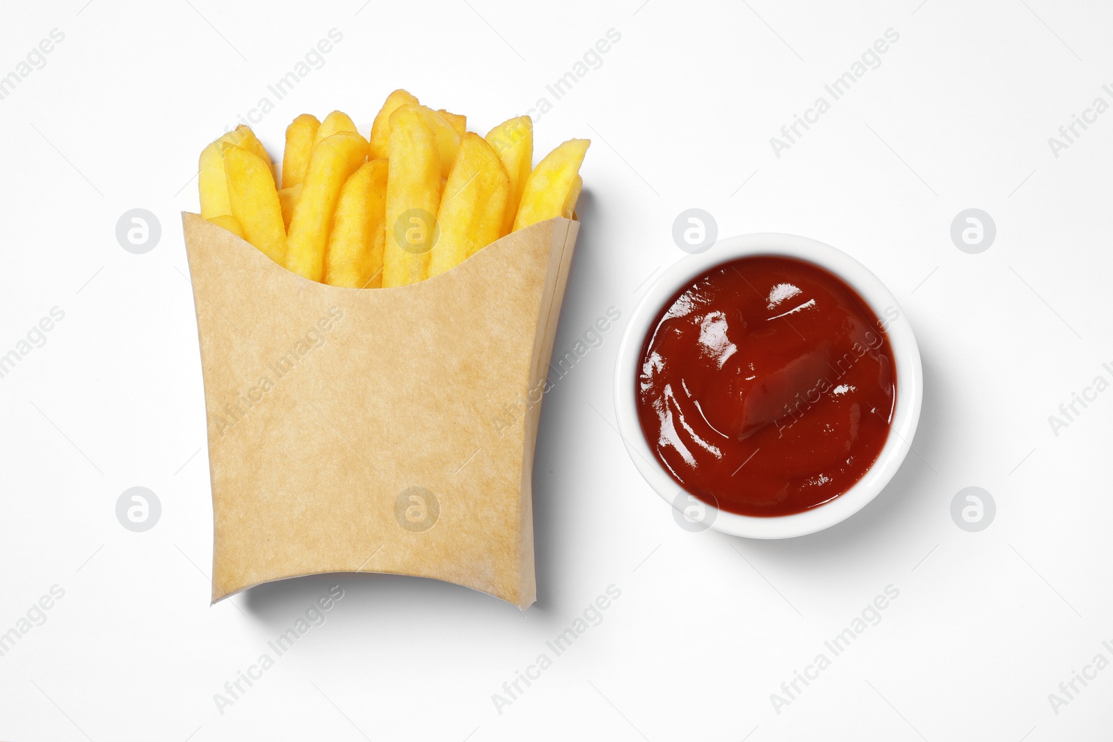 Photo of Paper cup with French fries and ketchup on white table, flat lay