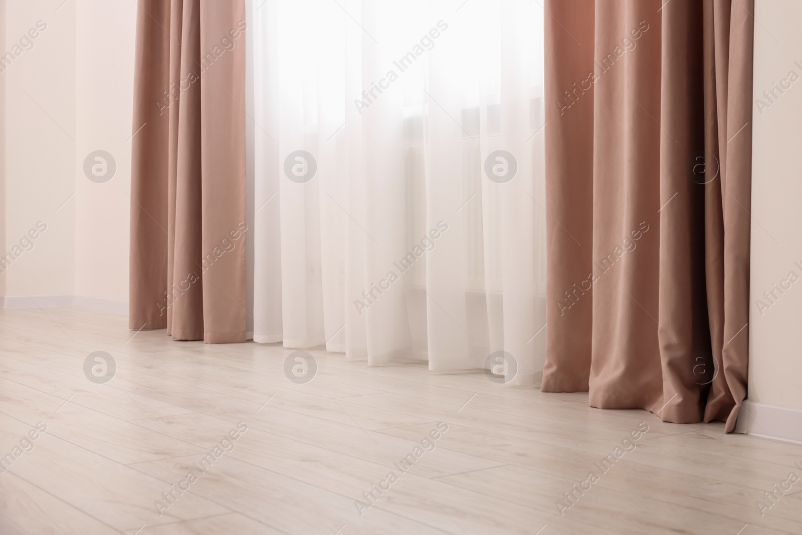 Photo of Elegant window curtains and white tulle indoors. Interior design