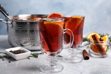 Photo of Tasty mulled wine with spices on grey marble table