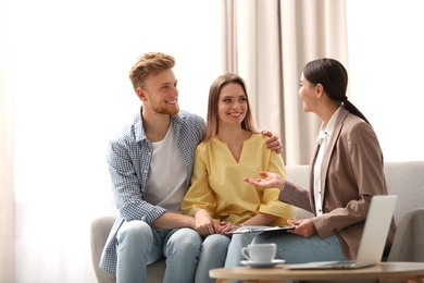 Female insurance agent working with young couple in office