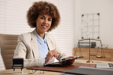 Photo of Notary with clipboard and pen at workplace in office