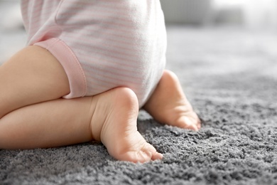 Closeup view of little baby on soft grey carpet