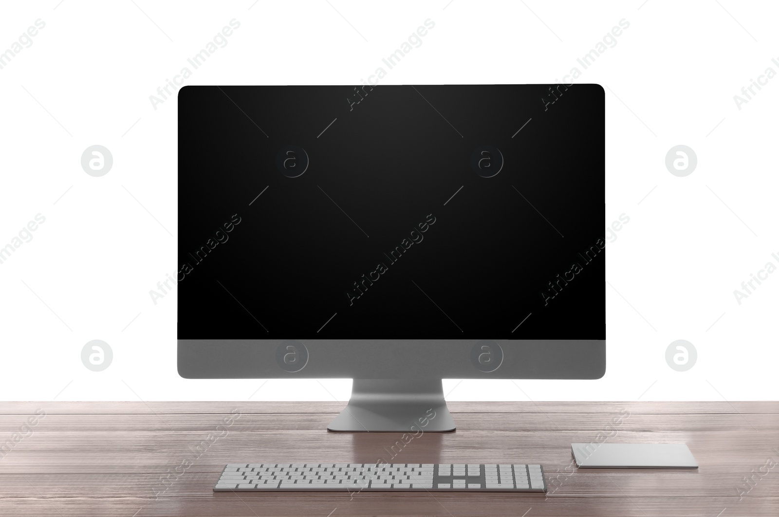 Photo of Modern computer with blank monitor screen and peripherals on wooden table against white background