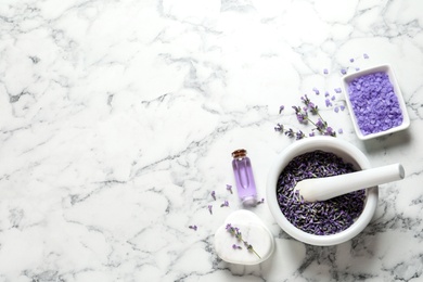 Photo of Flat lay composition with lavender flowers and natural cosmetic products on marble background. Space for text