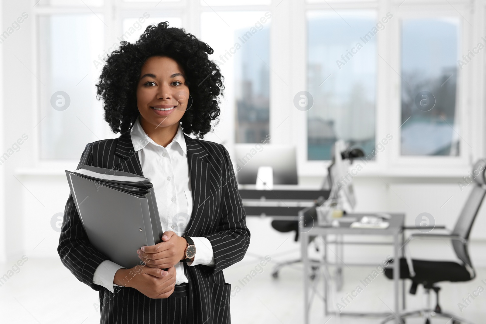 Photo of Smiling young businesswoman with folders in office. Space for text