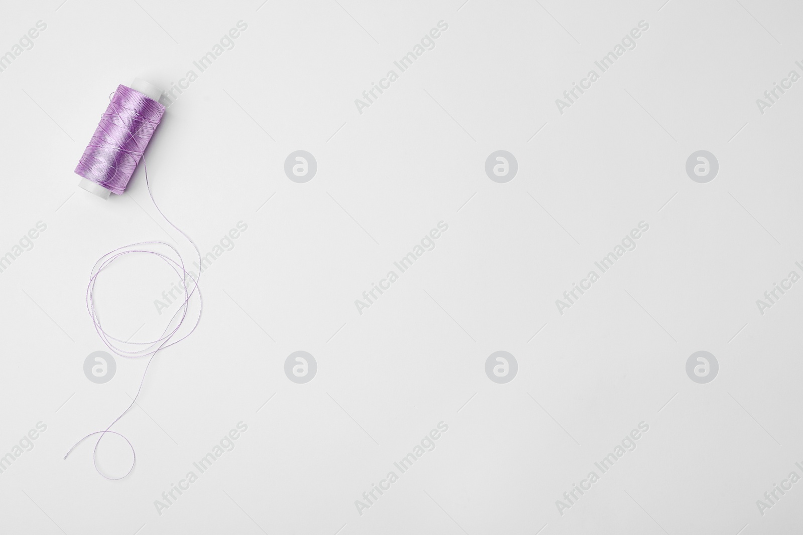 Photo of Color sewing thread on white background, top view