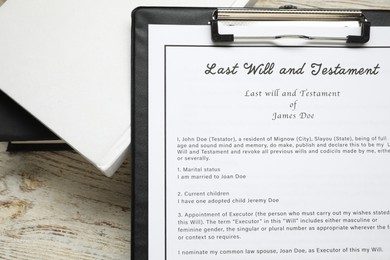 Photo of Last Will and Testament with books on white wooden table, top view