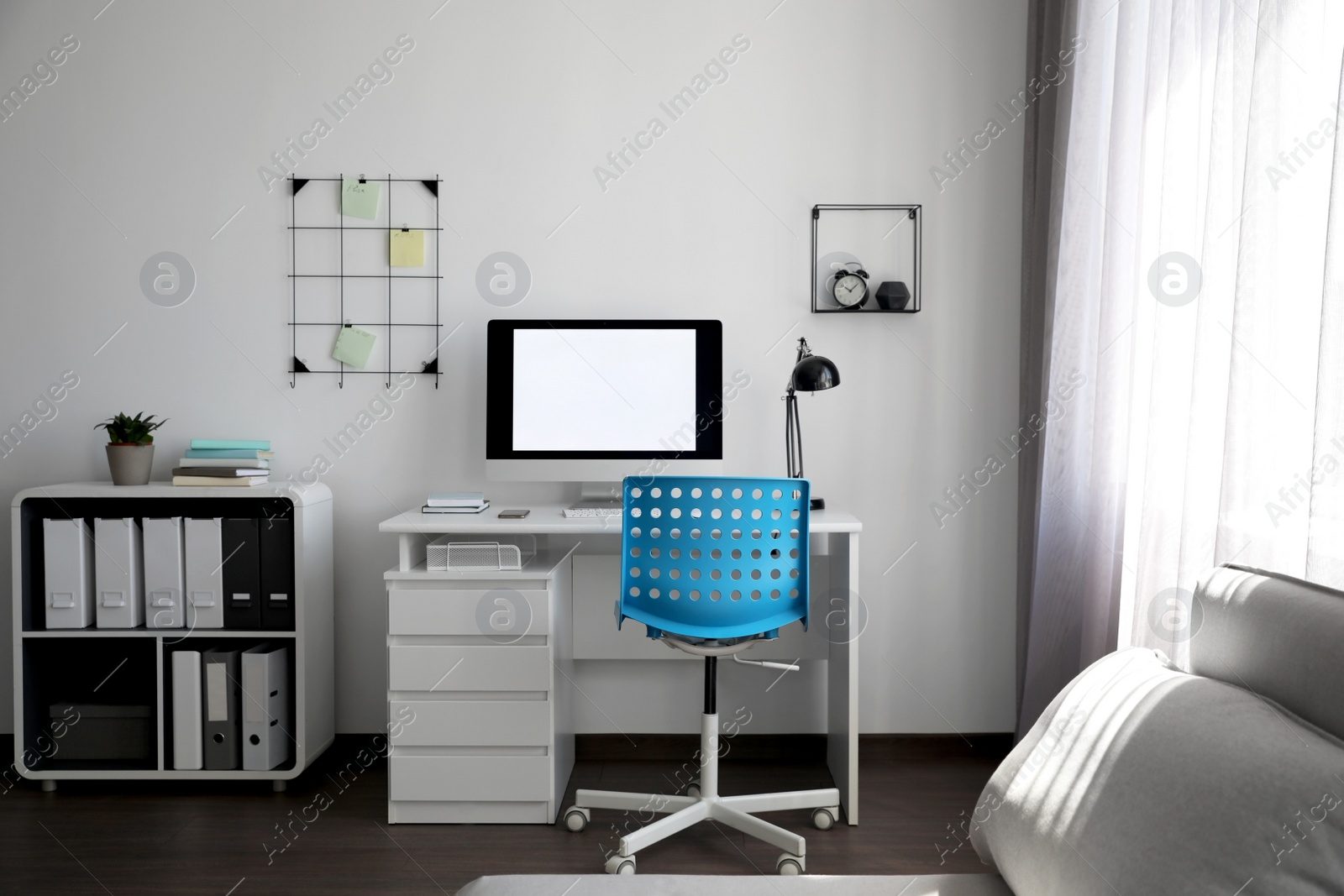 Photo of Comfortable blue chair near desk in stylish office interior