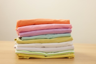 Photo of Stack of clean clothes on wooden table